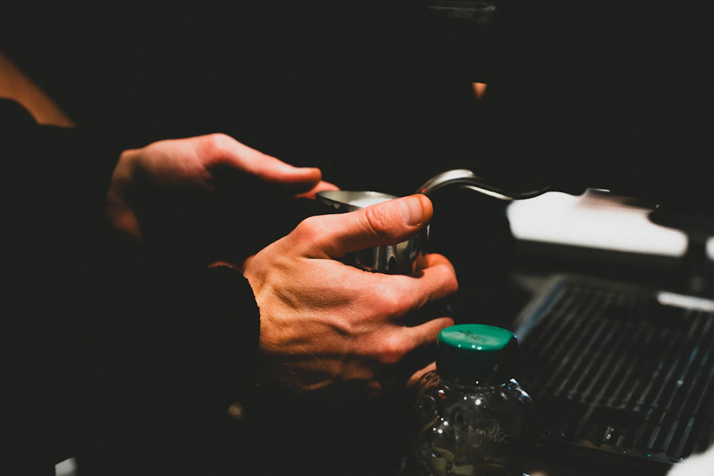 A barista working at an espresso machine in warm light