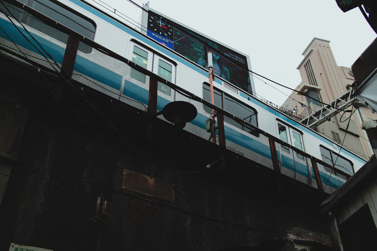 A blue and white commuter train moving through Tokyo